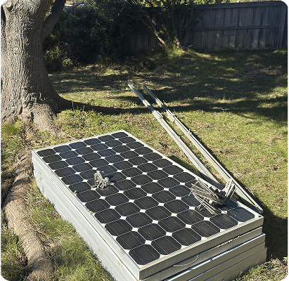 Stacked solar panels and rails on the lawn