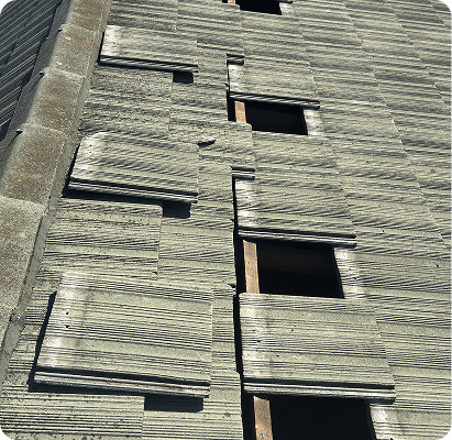 Concrete roof tiles lifted to expose the battens