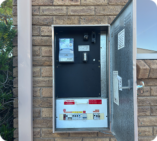 Open switchboard on a brick wall with an SMA inverter
