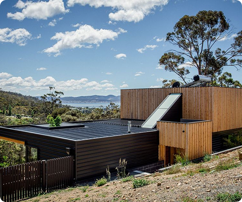 Modern Tasmanian home with rooftop solar overlooking the coast